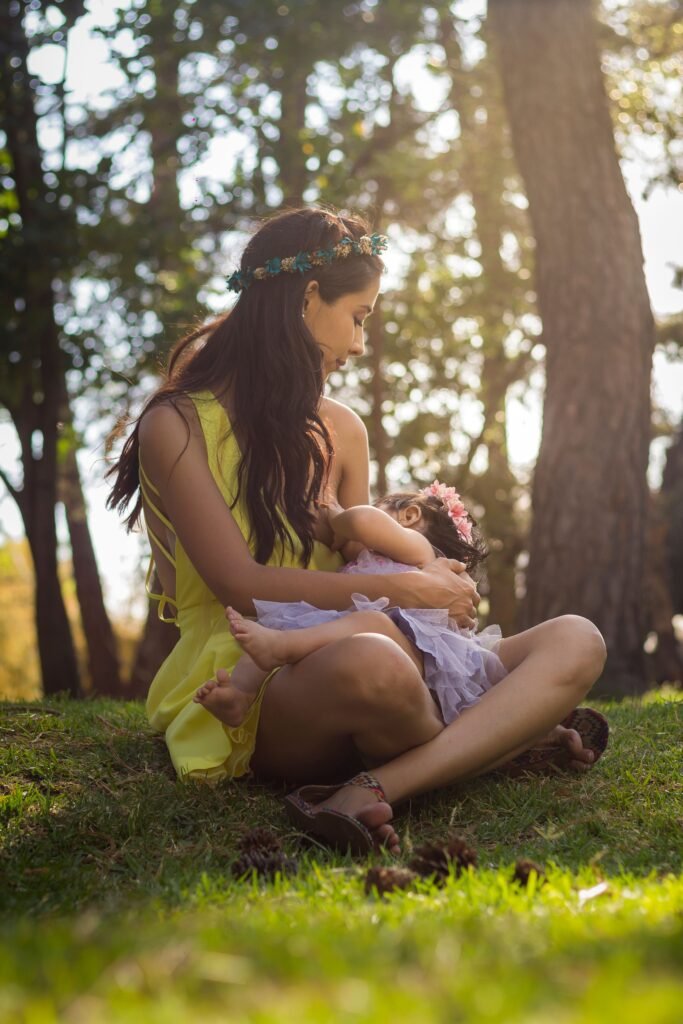 Mae segurando o bebe no colo de forma acolhedora enfrentando a agonia ao amamentar